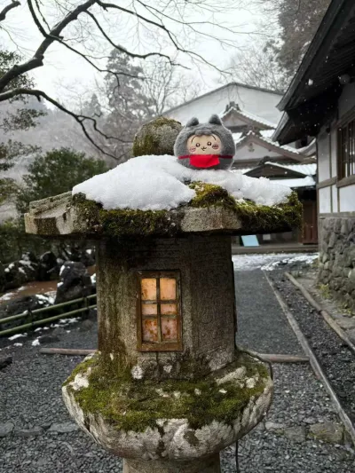 京都雪后石灯笼上的乌萨奇玩偶